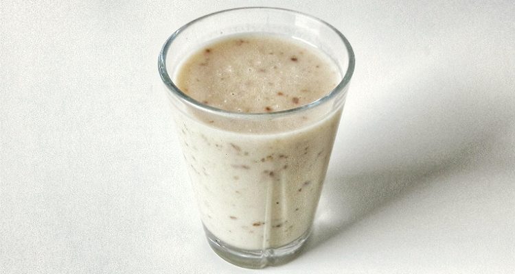 Glass of vegan banana tahini shake with dates